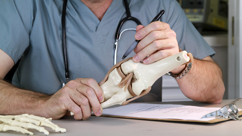 Doctor Holding Knee Joint